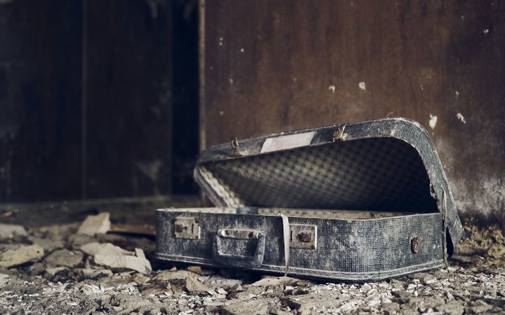 Weathered suitcase inside an abandoned destroyed house