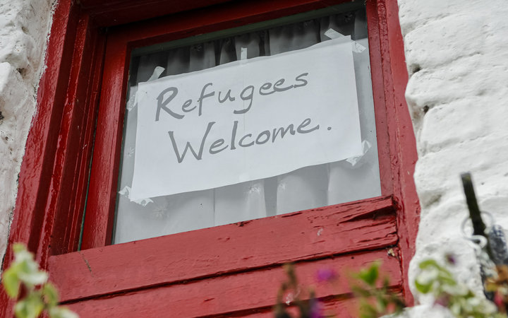 Schild auf einem Fenster mit der Aufschrift "Refugees Welcome"