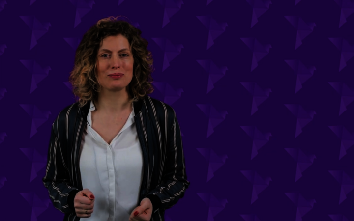 Foto von Friederike Krippner vor virtuellem Hintergrund mit dem stilisierten Friedenstauben-Logo der EKD-Friedensdenkschrift