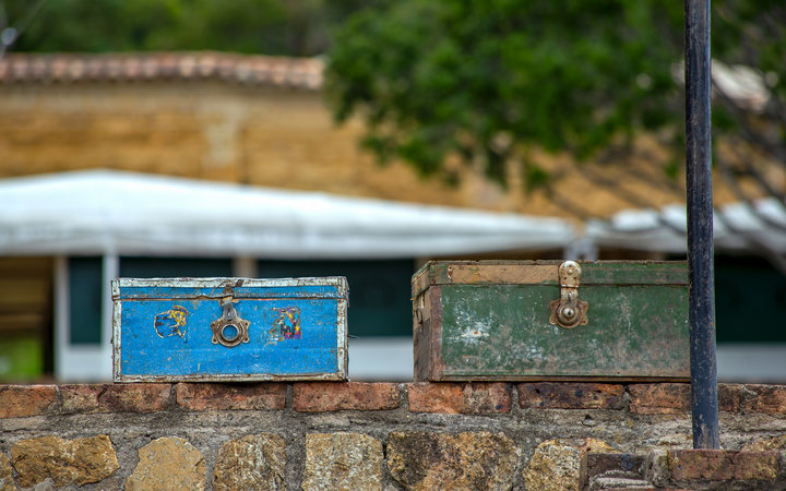 two vintage suitcases right on top of a some stone wall