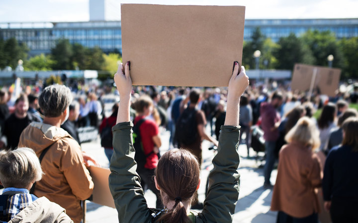 Rear view of people with placards and posters on global strike for climate change.