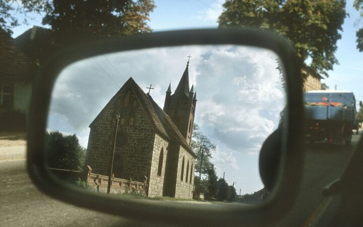Foto von einem Kirchengebäude im Rückspiegel eines Autos