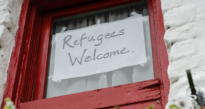 Schild auf einem Fenster mit der Aufschrift "Refugees Welcome"
