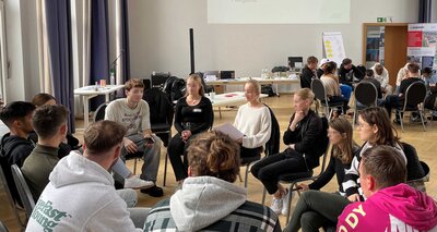 Jugendliche in zwei großen Stuhlkreisen bei einem Workshop