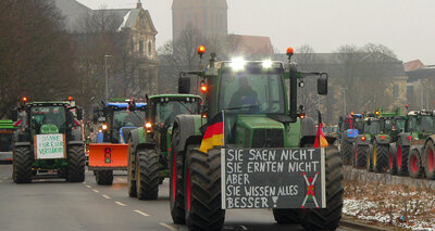 Kolonnen von Traktoren, teils mit Protestschildern